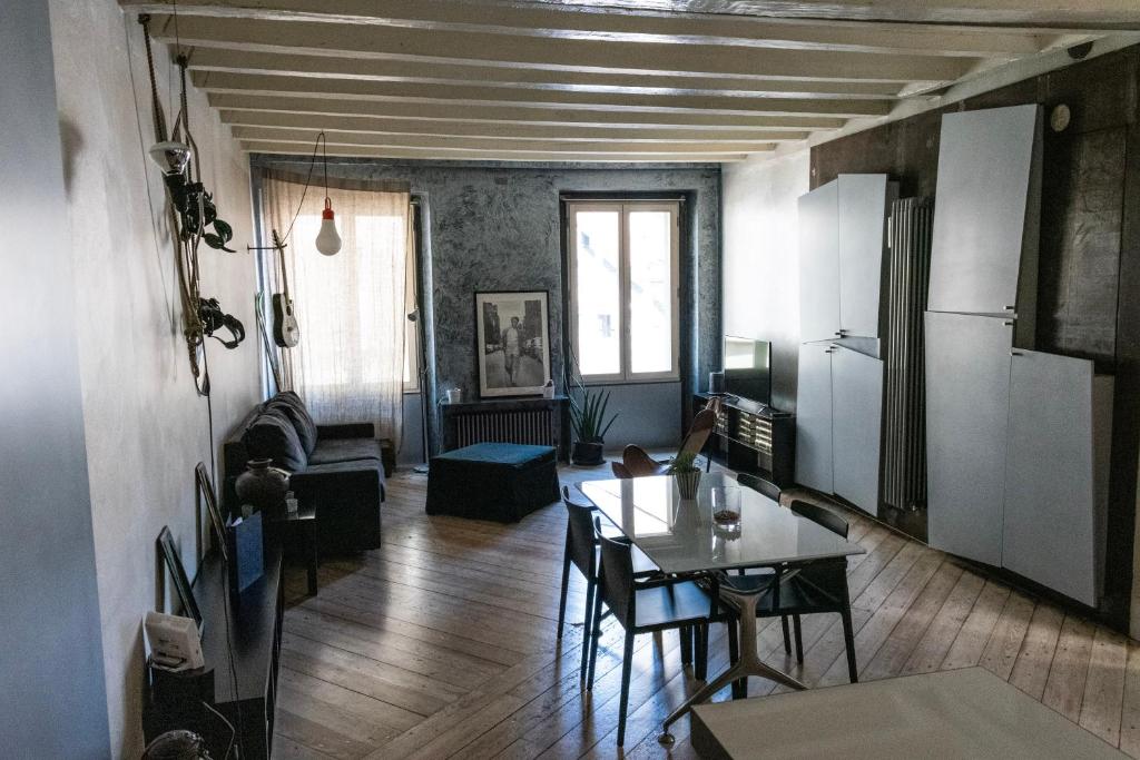 a living room with a table and a kitchen at Flora Inn Flora I - Appartamento nel cuore di Piazza Vecchia in Bergamo
