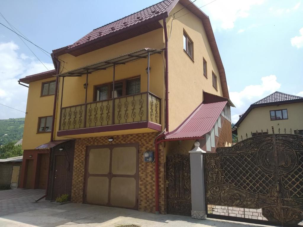 een geel huis met een balkon en een poort bij Camelot in Rakhiv