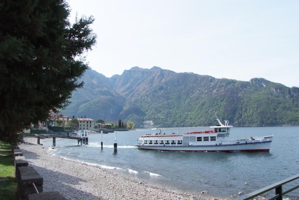 a boat on the water with mountains in the background at Veroalex in Abbadia Lariana