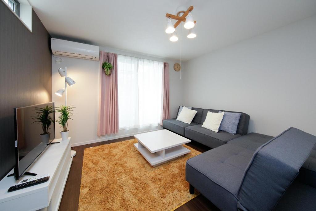 ein Wohnzimmer mit Sofa und Fernseher in der Unterkunft HigashirokugoBLACK / Vacation STAY 4280 in Tokio