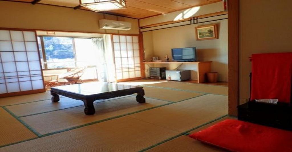 a living room with a table in the middle of a room at Oyado Matsubaya / Vacation STAY 8069 in Obinata