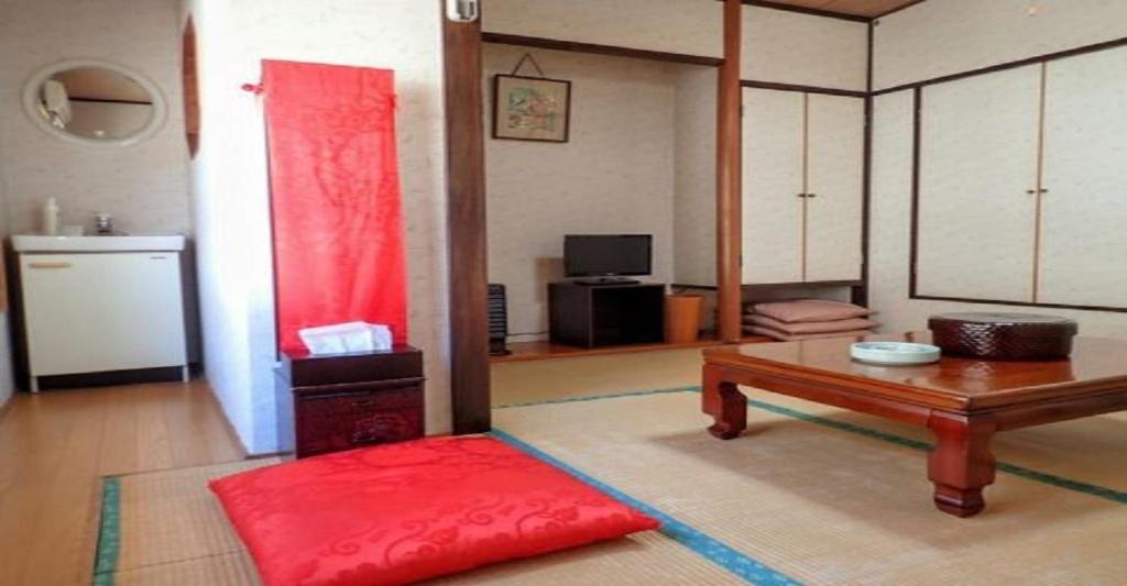 a living room with a table and a red rug at Oyado Matsubaya / Vacation STAY 8055 in Obinata