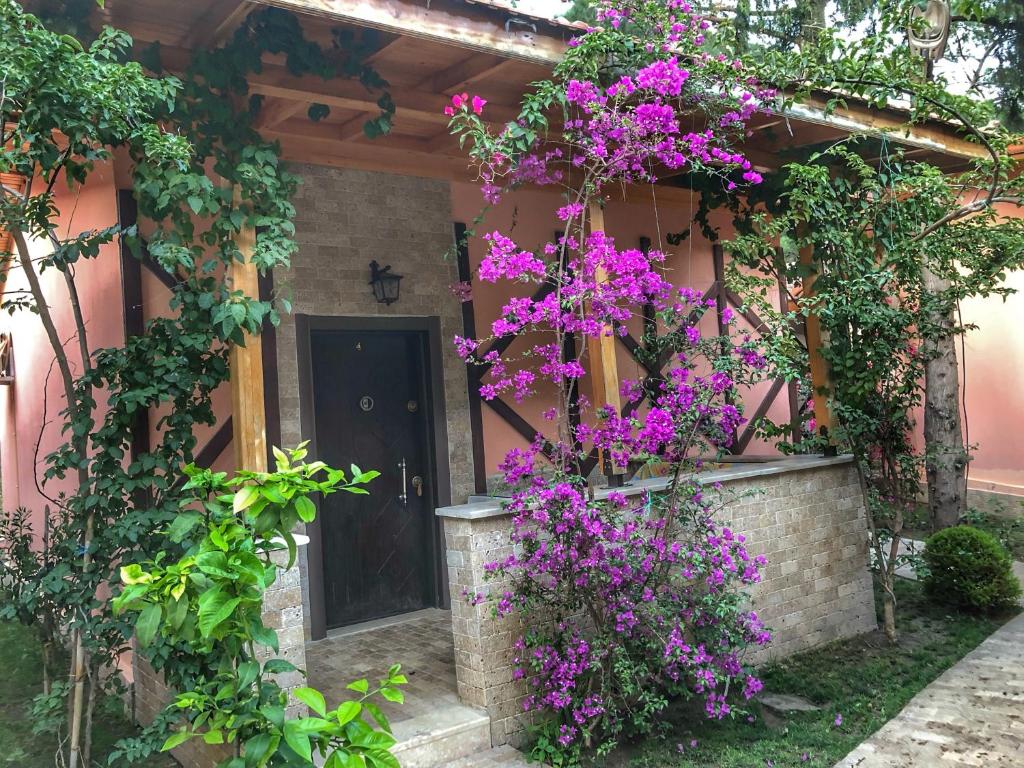 ein Haus mit lila Blumen auf der Vorderseite in der Unterkunft İpek Apart Hotel in Cıralı