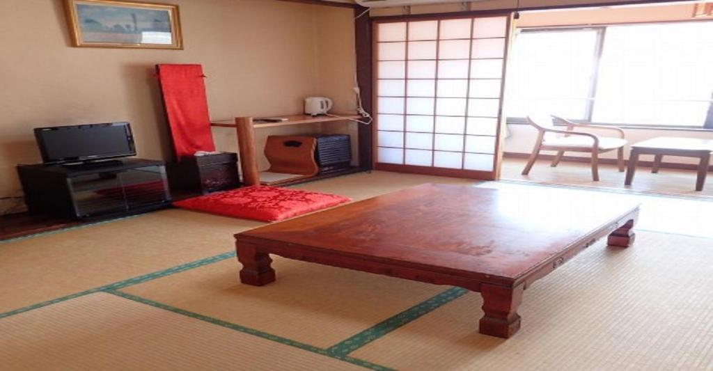 ein Wohnzimmer mit einem Couchtisch aus Holz im Zimmer in der Unterkunft Oyado Matsubaya / Vacation STAY 8061 in Obinata