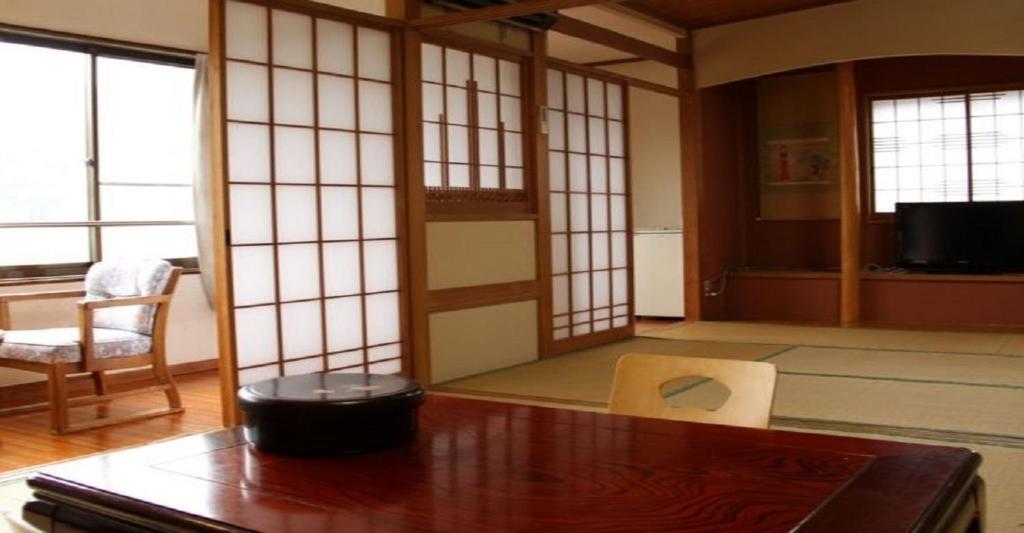 Zimmer mit einem Tisch, einem Stuhl und Fenstern in der Unterkunft Oyado Matsubaya / Vacation STAY 8064 in Obinata