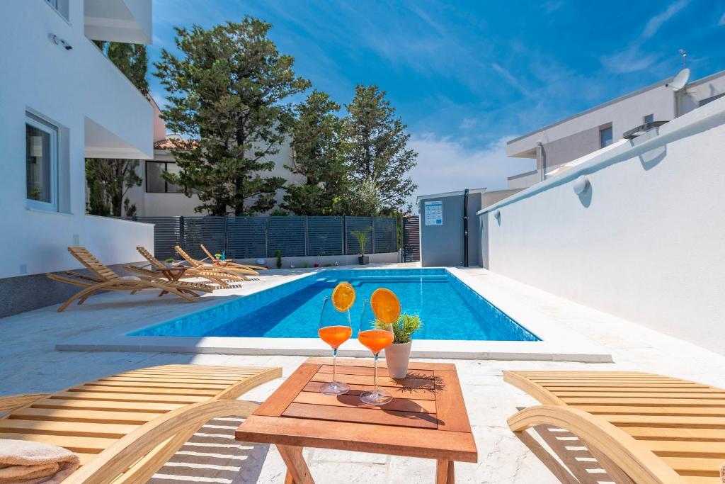 patio ze stołem i basenem w obiekcie Villa Star 5 a centrally located ap. with a pool w Novalji