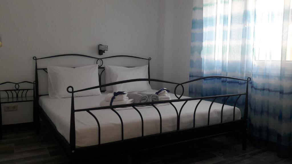 um quarto com uma cama preta e almofadas brancas em Friends 2 Apartment em Perea