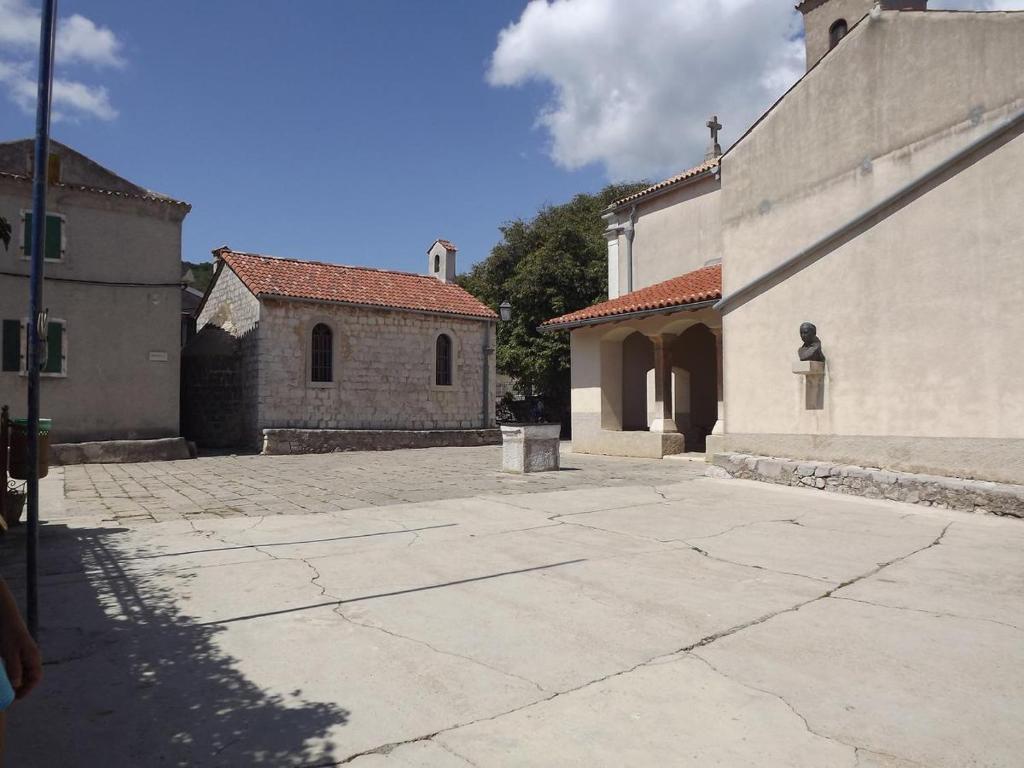an empty courtyard of a building with a church at Villa Frane 101 in Beli