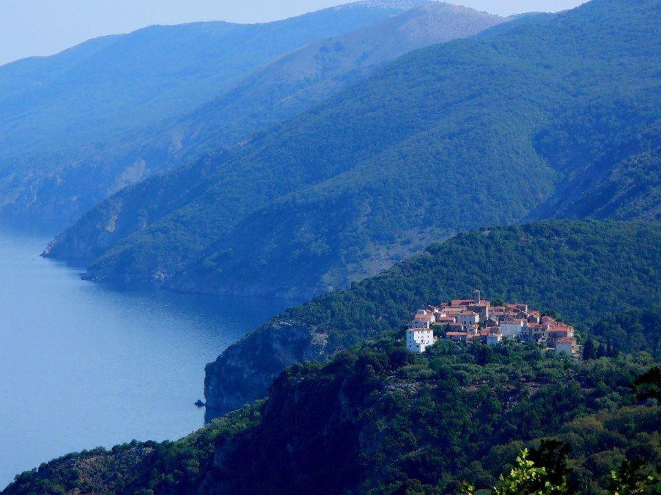 a house on a hill next to a body of water at Villa Frane 101 in Beli