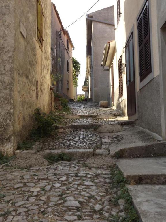 an alley with a stone walkway between two buildings at Villa Frane 101 in Beli