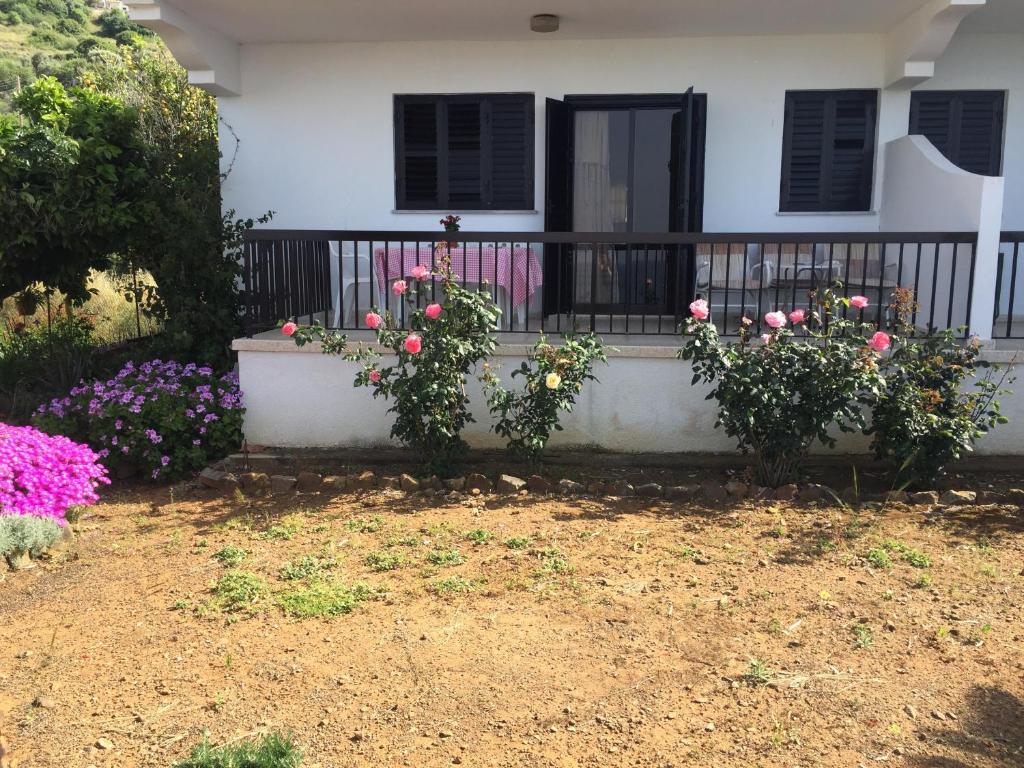 a house with flowers in front of a porch at Apartment with stunning sea view in Pachyammos