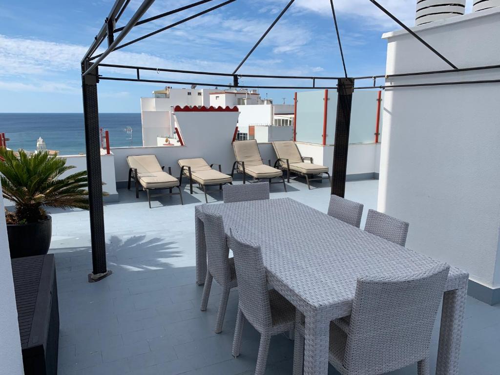 ポルティマンにあるAppartement Luxueux 4 Pièces, terrasse 120M2 vue mer PRAIA DA ROCHAの白いテーブルと椅子、海を望むバルコニー