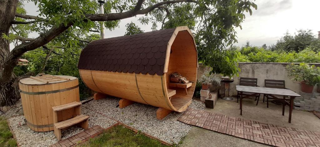una grande barca di legno seduta accanto a un tavolo di SAUNA Dom a Pezinok