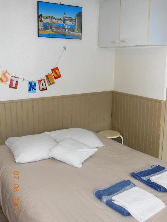 une chambre avec un lit avec des serviettes dessus dans l'établissement studio bord de mer, SAINT MALO, à Saint-Malo