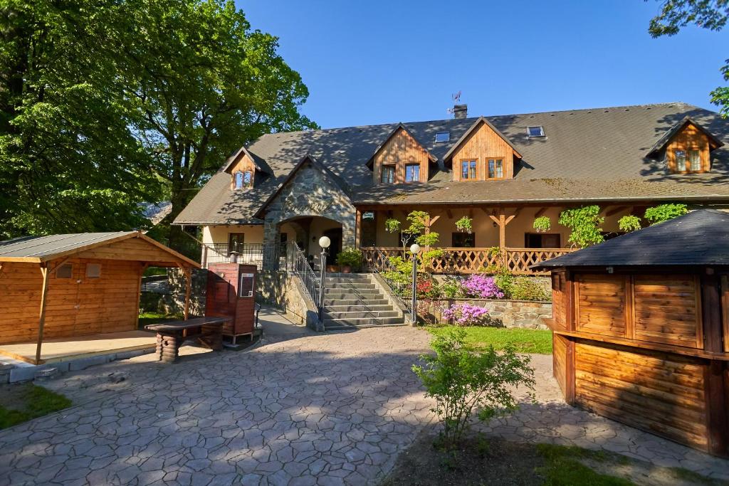 una casa grande con una puerta y una valla en Pension Restaurant Bobrovník, en Lipová-lázně