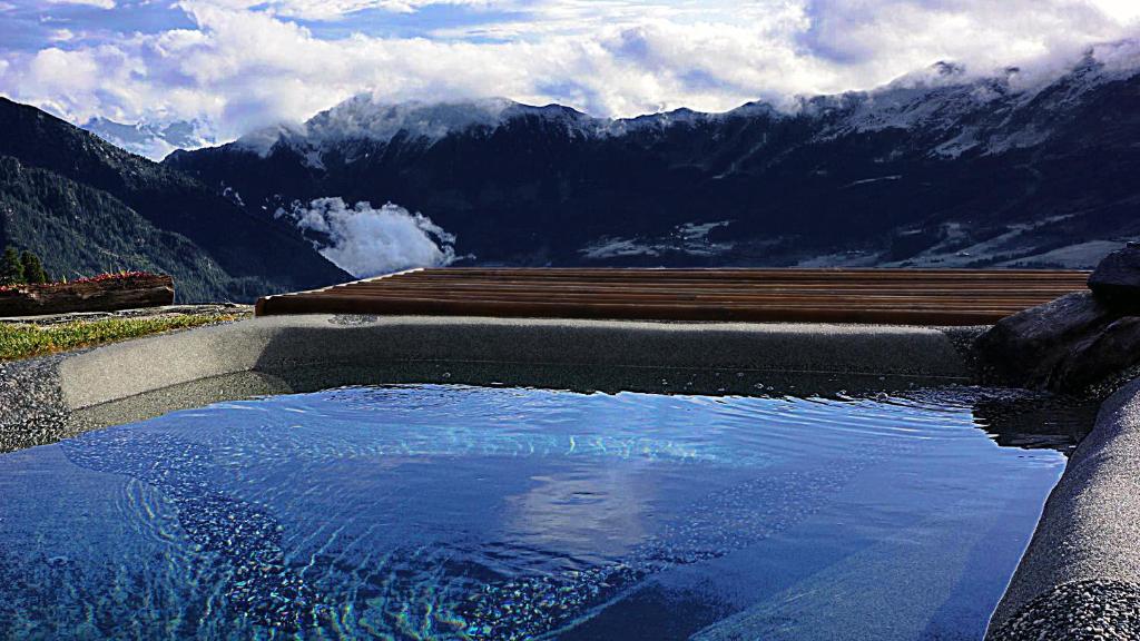 a pool of water with mountains in the background at Rifugio Baita Belvedere in Champoluc