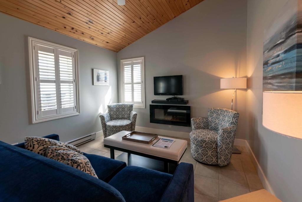 a living room with a blue couch and chairs at Lantern Hill & Hollow in Ingonish Beach