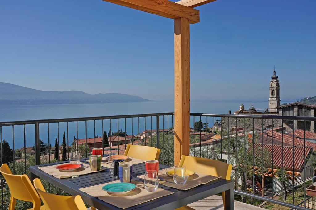 un tavolo su un balcone con vista sull'oceano di Residence Dany appartamenti con cucina vista lago piscina e parcheggio a Gargnano