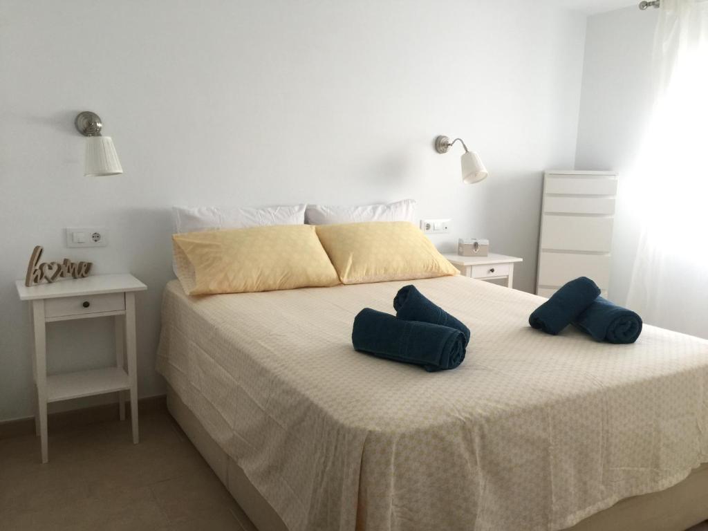 sypialnia z łóżkiem z 2 niebieskimi poduszkami w obiekcie Casa Luz w mieście Tarifa