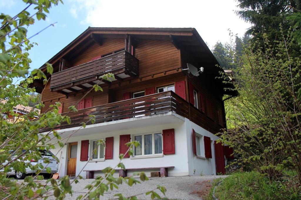 a wooden house with a balcony on top of it at Haus Siegfried in Churwalden
