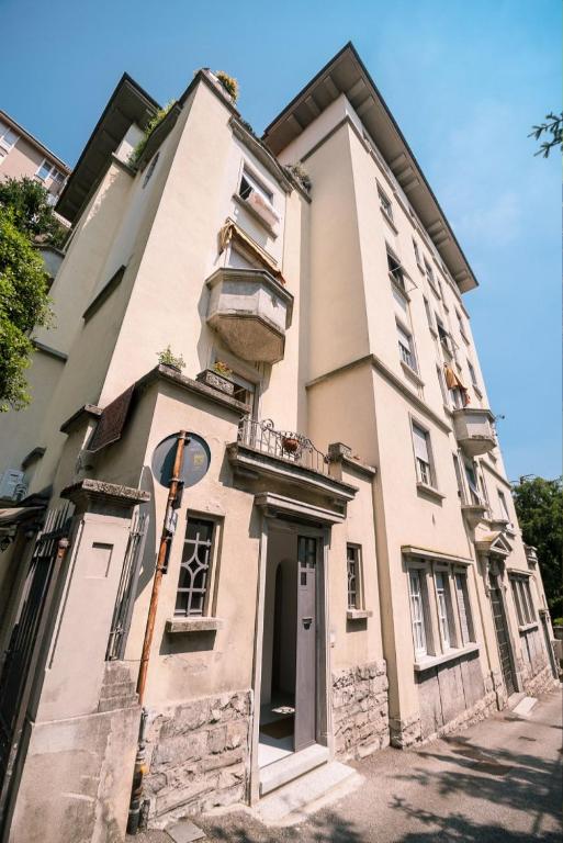 un edificio bianco con un balcone su una strada di Alex Suite a Como