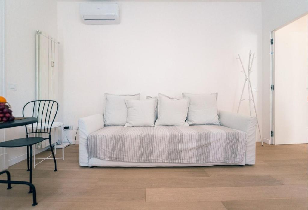 un letto bianco con quattro cuscini in una stanza di Alex Suite a Como