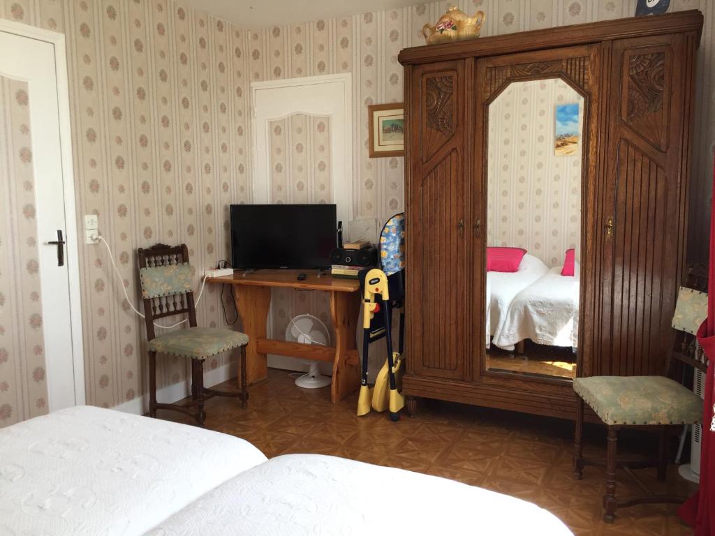 a bedroom with a desk with a bed and a mirror at Les Galets in Tracy-sur-Mer