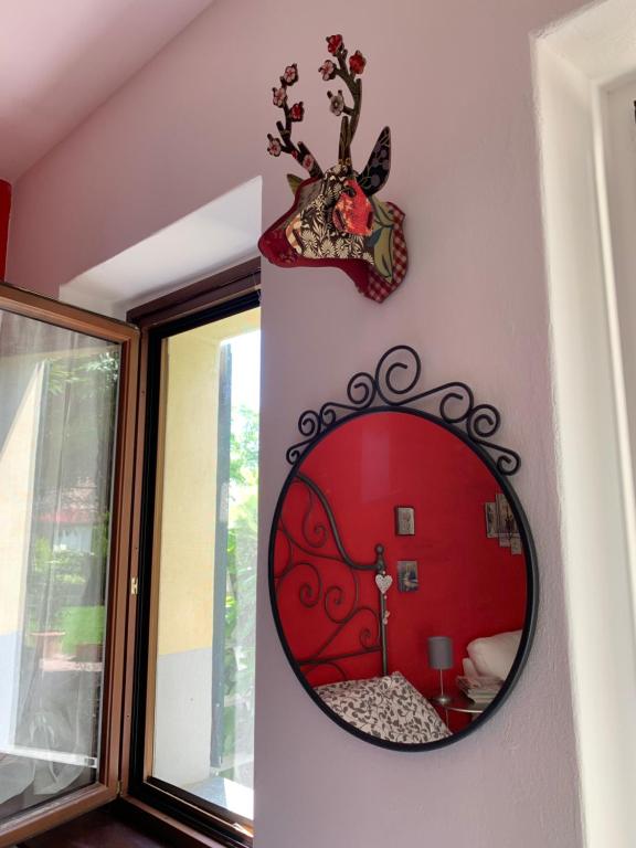 a mirror on a wall with a red room at Ca' degli Ovi in Valenza