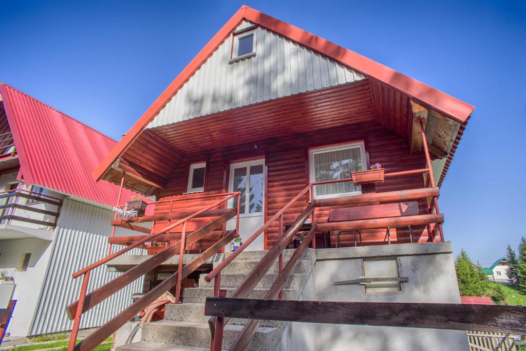 a wooden house with stairs leading up to it at Vuković Accommodation in Žabljak