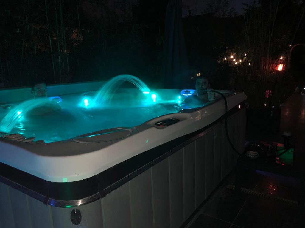 two people in a jacuzzi tub at night at La Lilloise Villeneuve D'Ascq GD STADE Mauroy in Villeneuve d'Ascq