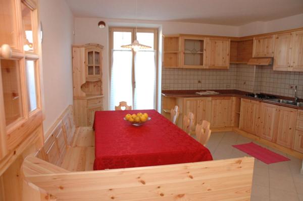 una cocina con una mesa roja con un bol de fruta. en Agritur Al Paradis - Appartamenti, en Portolo