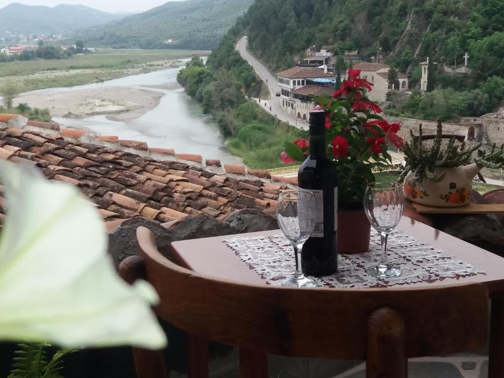 a table with a bottle of wine and two glasses at Guest House Mikel in Berat