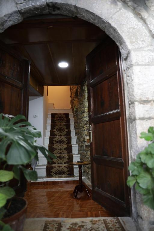 an entrance to a house with a wooden door and stairs at Guest House Mikel in Berat