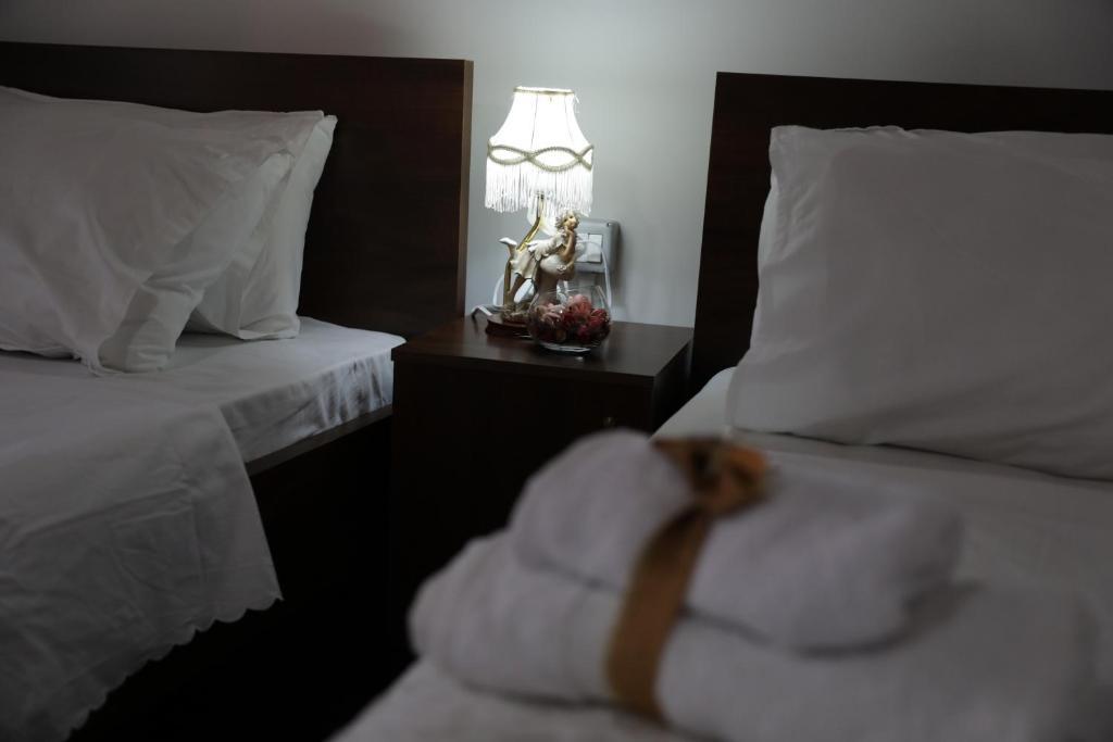 a bedroom with two beds and a table with a lamp at Guest House Mikel in Berat