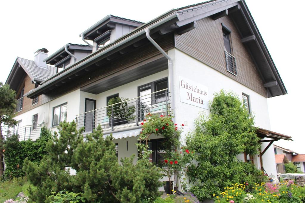 Ein weißes Gebäude mit einem Schild drauf. in der Unterkunft Gästehaus Maria in Rettenbach am Auerberg