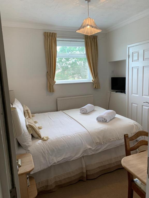 1 dormitorio con 1 cama blanca grande y ventana en Rivendell Guest House, en Southampton