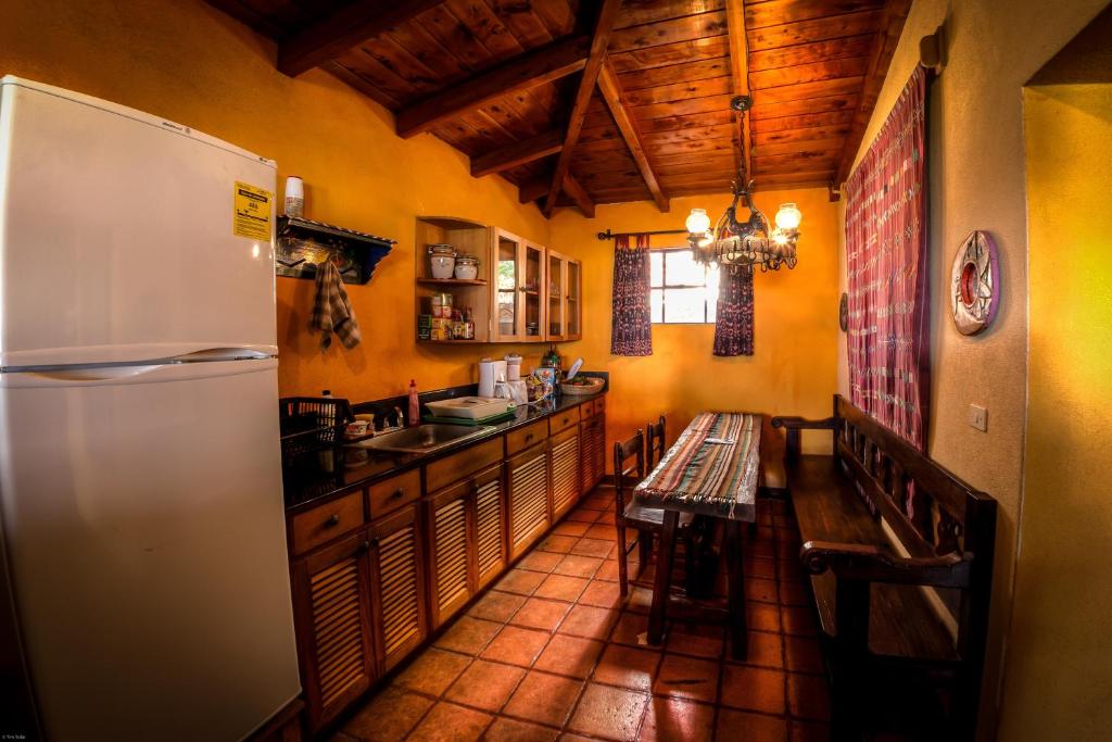 eine Küche mit einem Kühlschrank und einem Tisch darin in der Unterkunft Casa Hagan in Santa Cruz La Laguna