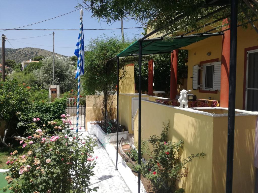 a house with a flag and flowers in front of it at Relaxing Beautiful Holiday Home in Lávrion