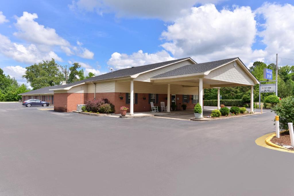een gebouw met een auto geparkeerd op een parkeerplaats bij The Heritage Inn, Inc in Huntingdon