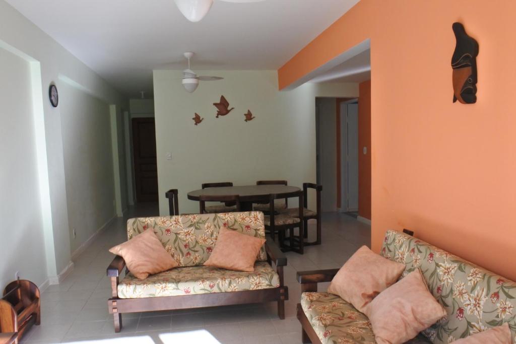 a living room with two couches and a table at Apto praia Martim de Sá in Caraguatatuba