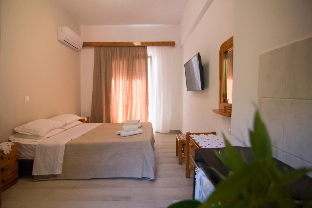 una camera d'albergo con letto e finestra di Athina Studios a Paleokastritsa