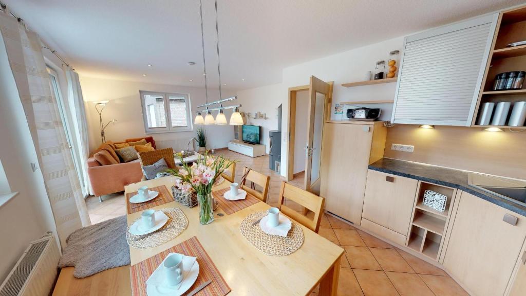 a kitchen and living room with a table and chairs at Feriendorf Südstrand Haus 09 in Pelzerhaken