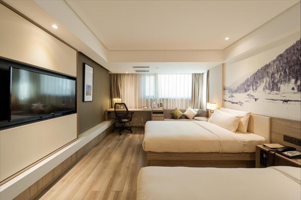 a hotel room with two beds and a flat screen tv at Atour Harbin Museum Hotel in Harbin