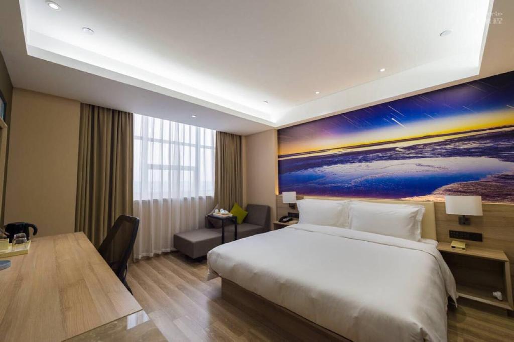 a hotel room with a large bed and a desk at Atour Hotel (Dongying Huanghe Road) in Dongying