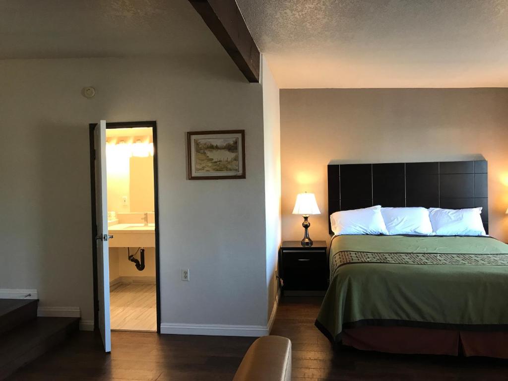 a hotel room with a bed and a bathroom at Manhattan Inn & Suites in Manhattan Beach
