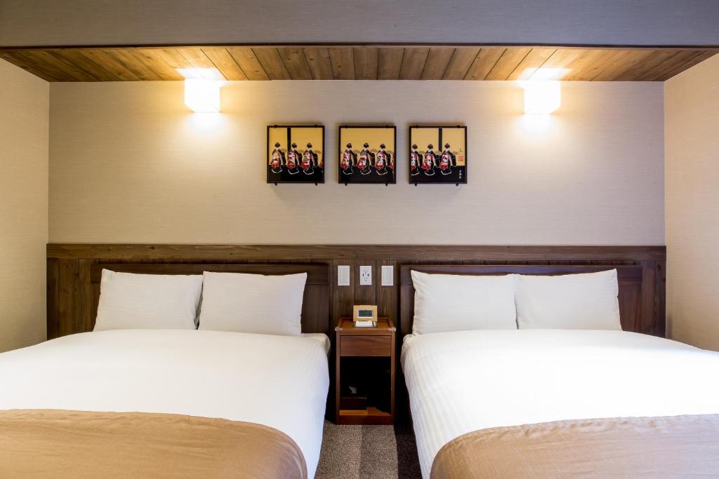 two beds in a hotel room with two beds at RESI STAY NISHIKI in Kyoto