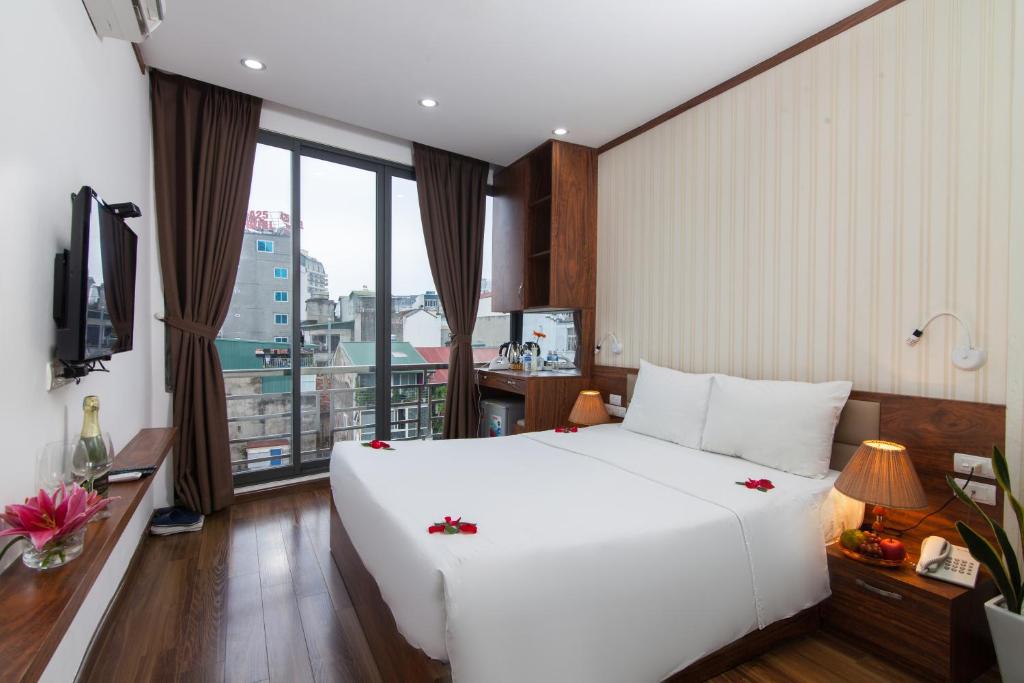Postel nebo postele na pokoji v ubytování Hanoi Bel Ami Hotel