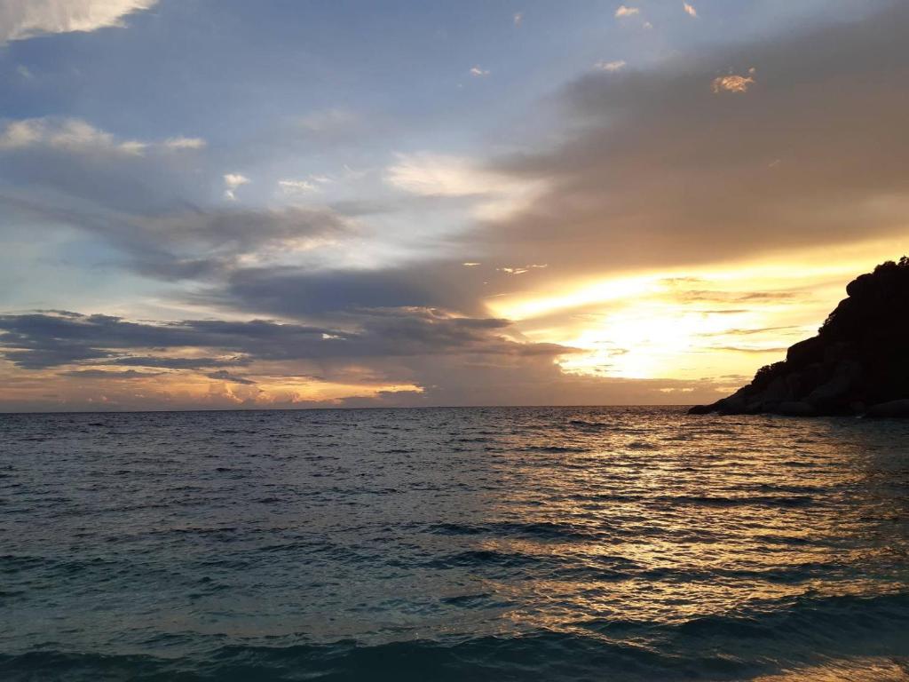 a sunset over a body of water with the ocean at Nangyuan Island Dive Resort in Ko Tao