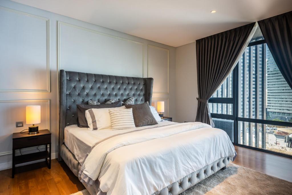 a bedroom with a large bed and a large window at Anggun Residences Luxe in Kuala Lumpur