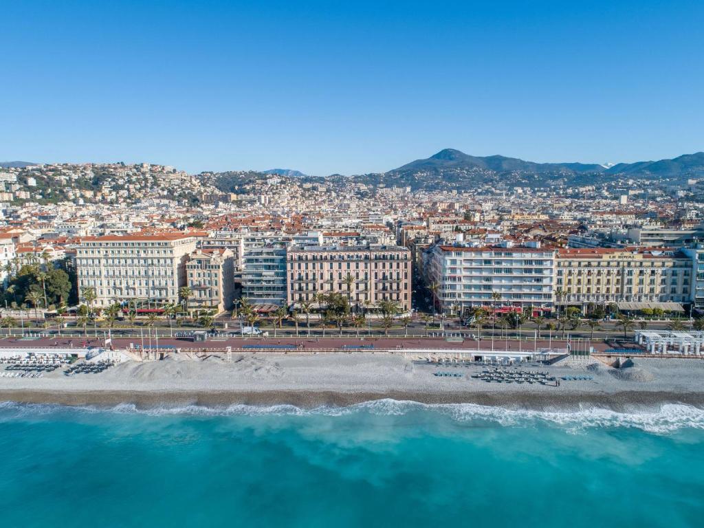 Blick auf einen Strand mit Gebäuden und das Meer in der Unterkunft Westminster Hotel & Spa Nice in Nizza